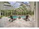 Stunning pool area with lounge chairs, a fire pit, and lush landscaping, perfect for outdoor relaxation and entertainment at 168 Rue Des Chateaux, Tarpon Springs, FL 34688