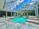 Resort-style pool with screened enclosure, tile accents, and blue skies above at 168 Rue Des Chateaux, Tarpon Springs, FL 34688