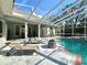 Relaxing pool area with lounge chairs, fire pit, and a screened enclosure for year-round enjoyment at 168 Rue Des Chateaux, Tarpon Springs, FL 34688