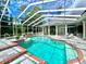 Gorgeous screened pool with water feature and ample patio seating under a clear blue sky at 168 Rue Des Chateaux, Tarpon Springs, FL 34688