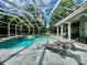 Inviting screened pool area with a spa, lounge chairs, and scenic backyard views at 168 Rue Des Chateaux, Tarpon Springs, FL 34688