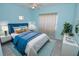 This spacious bedroom features blue walls, a plush bed and large window for natural light at 4336 Bayside Village Dr # 201, Tampa, FL 33615