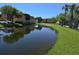 Scenic view of a tranquil pond reflecting the surrounding buildings and lush greenery at 4336 Bayside Village Dr # 201, Tampa, FL 33615