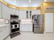 Modern kitchen with white cabinets, stainless steel appliances, and an island at 15810 Cobble Mill Dr, Wimauma, FL 33598