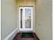 White front door with etched glass and a green welcome mat at 15810 Cobble Mill Dr, Wimauma, FL 33598