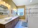 Modern bathroom with double vanity, large shower, and window at 15810 Cobble Mill Dr, Wimauma, FL 33598
