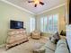 Comfortable guest room with sofa bed, TV, and built-in shelving at 15810 Cobble Mill Dr, Wimauma, FL 33598