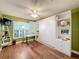 Bright bedroom with hardwood floors, large window, and built-in murphy bed at 15810 Cobble Mill Dr, Wimauma, FL 33598