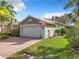 Well-maintained house with a two-car garage and manicured lawn at 15810 Cobble Mill Dr, Wimauma, FL 33598