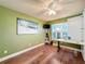 Bright bedroom with hardwood floors, large window, and craft table at 15810 Cobble Mill Dr, Wimauma, FL 33598