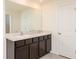 Bathroom with a double vanity, dark brown cabinets, and a large mirror at 12197 Downy Birch Dr, Riverview, FL 33569