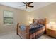 Bright bedroom with a wooden bed frame and a window overlooking the backyard at 3320 Majestic View Dr, Lutz, FL 33558