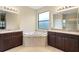 Elegant bathroom with double vanity, soaking tub, and large window at 3320 Majestic View Dr, Lutz, FL 33558