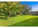 Spacious backyard with lush green grass and mature trees at 3320 Majestic View Dr, Lutz, FL 33558
