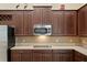 Kitchen features dark wood cabinets and a cooktop at 3320 Majestic View Dr, Lutz, FL 33558