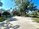 Large driveway, basketball court, home, and pond view at 168 Rue Des Chateaux, Tarpon Springs, FL 34688