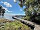 Wooden dock extends over calm lake water, offering scenic views and boat access at 168 Rue Des Chateaux, Tarpon Springs, FL 34688