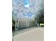 Three-car garage with light gray doors and architectural details at 168 Rue Des Chateaux, Tarpon Springs, FL 34688