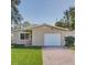 Tan single story home with attached garage and manicured lawn at 1818 Michigan Ne Ave, St Petersburg, FL 33703