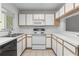 Galley kitchen featuring white cabinets and black appliances at 1326 Twilridge Pl, Brandon, FL 33511