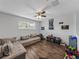Bonus room with sectional sofa, ceiling fan, and wood floors at 8720 Savory Walk Dr, Land O Lakes, FL 34637
