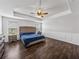 Main bedroom with wood flooring, tray ceiling and a large bed at 8720 Savory Walk Dr, Land O Lakes, FL 34637
