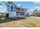 Two-story waterfront home with blue exterior and large deck at 70 Gulfwinds Dr, Palm Harbor, FL 34683