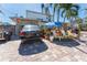 Brick paved front yard with tropical landscaping and seating at 14180 W Parsley Dr, Madeira Beach, FL 33708