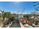Distressed property with canal view, damaged landscaping, and inground pool at 14180 W Parsley Dr, Madeira Beach, FL 33708