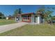 Newly renovated home with a modern exterior, featuring a green door and brown accents at 1328 Barry St, Clearwater, FL 33756