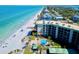 Beachfront condo overlooking the ocean with a pool and palm trees along a sandy beach at 2618 Gulf Blvd # 407, Indian Rocks Beach, FL 33785