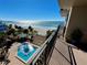 Overhead balcony view of pool, beach, the Gulf, and a covered seating area at 2618 Gulf Blvd # 407, Indian Rocks Beach, FL 33785