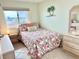Comfortable bedroom featuring tile floors, a beach-themed quilt and decor, and lots of natural light at 2618 Gulf Blvd # 407, Indian Rocks Beach, FL 33785