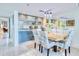 Elegant dining room featuring a modern chandelier and an open layout connected to kitchen at 2618 Gulf Blvd # 407, Indian Rocks Beach, FL 33785
