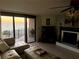 Cozy living room with tile flooring, fireplace, and ocean view balcony access at 2618 Gulf Blvd # 407, Indian Rocks Beach, FL 33785