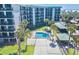 Aerial view of the pool, the condos, the deck area, and manicured landscaping at 2618 Gulf Blvd # 407, Indian Rocks Beach, FL 33785