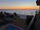 Balcony view of the sun setting over the beach, ocean, and community pool at 2618 Gulf Blvd # 407, Indian Rocks Beach, FL 33785