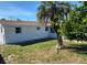 Expansive backyard featuring green grass, a palm tree and some shrubs at 4803 Guardian Ave, Holiday, FL 34690