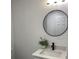 This bathroom features a round mirror, undermount sink, and modern lighting at 4803 Guardian Ave, Holiday, FL 34690