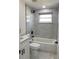 Stylish bathroom featuring new vanity, toilet, tub and decorative marble tile at 4803 Guardian Ave, Holiday, FL 34690