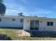 Home's rear exterior featuring sliding glass doors with backyard access at 4803 Guardian Ave, Holiday, FL 34690