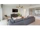 Comfortable living room area with a sofa, TV, and modern decor at 6674 Michael Favor Way, Wesley Chapel, FL 33545