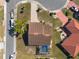 Aerial view of a home featuring a pool, mature landscaping, and manicured lawns at 701 Westmont Way, Sun City Center, FL 33573