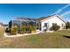 A backyard with a screened-in pool, patio, and lush green landscaping at 701 Westmont Way, Sun City Center, FL 33573