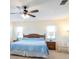 Primary bedroom with ceiling fan, two windows, rocking chair, and queen bed at 701 Westmont Way, Sun City Center, FL 33573