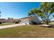 Well-maintained home featuring a two-car garage, a long driveway, and mature landscaping at 701 Westmont Way, Sun City Center, FL 33573
