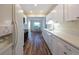 Bright kitchen features white cabinetry, stainless steel appliances, and hardwood flooring leading to a dining area at 701 Westmont Way, Sun City Center, FL 33573