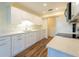 Bright kitchen boasts white cabinets, quartz countertops, stainless steel appliances, and wood flooring at 701 Westmont Way, Sun City Center, FL 33573
