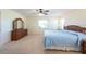 Spacious primary bedroom with wooden furniture, carpeted flooring, ceiling fan, and two windows at 701 Westmont Way, Sun City Center, FL 33573