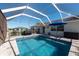 A view of the screened-in pool area with its cool blue water and tiled patio invites relaxation at 701 Westmont Way, Sun City Center, FL 33573